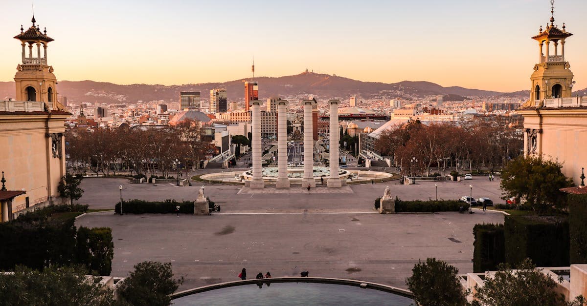 Zonsondergang over de barcelona weer skyline vanaf Montjuïc met historische architectuur en stadslichten.