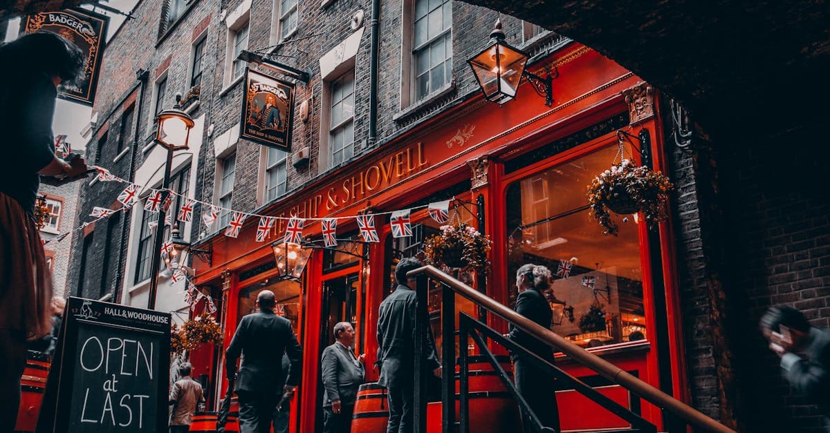 Pub londinense decorado con banderas Union Jack lleno de ambiente navideño y gente celebrando.
