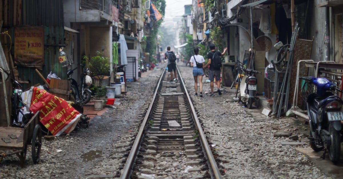 Turist navigerer Hanois smalle hanoi alley street food-gyder langs de ikoniske jernbanespor med mobil