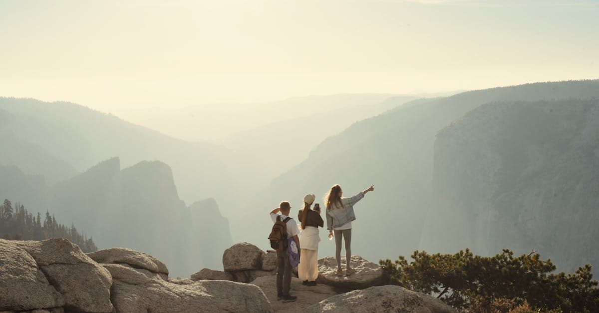 Group of friends hiking the dramatic cliffs of Yosemite National Park on a bright sunny day.