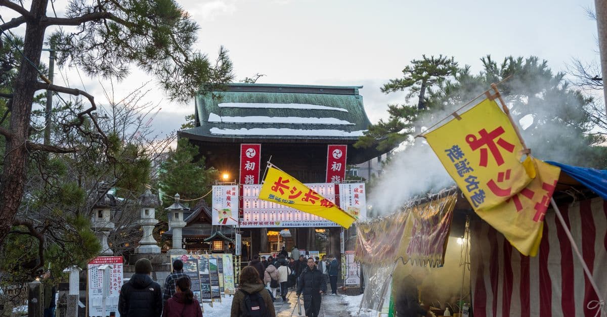 正月に休みとなる国の伝統的な寺院市場で、屋台と色鮮やかな旗の下に人々が集まる冬の風景。