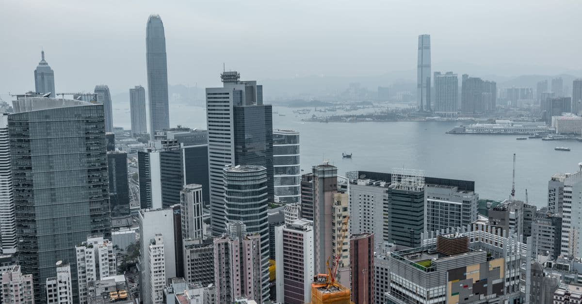 Elevated perspective of Hong Kong's modern skyscrapers and Victoria Harbour from above the financial district.