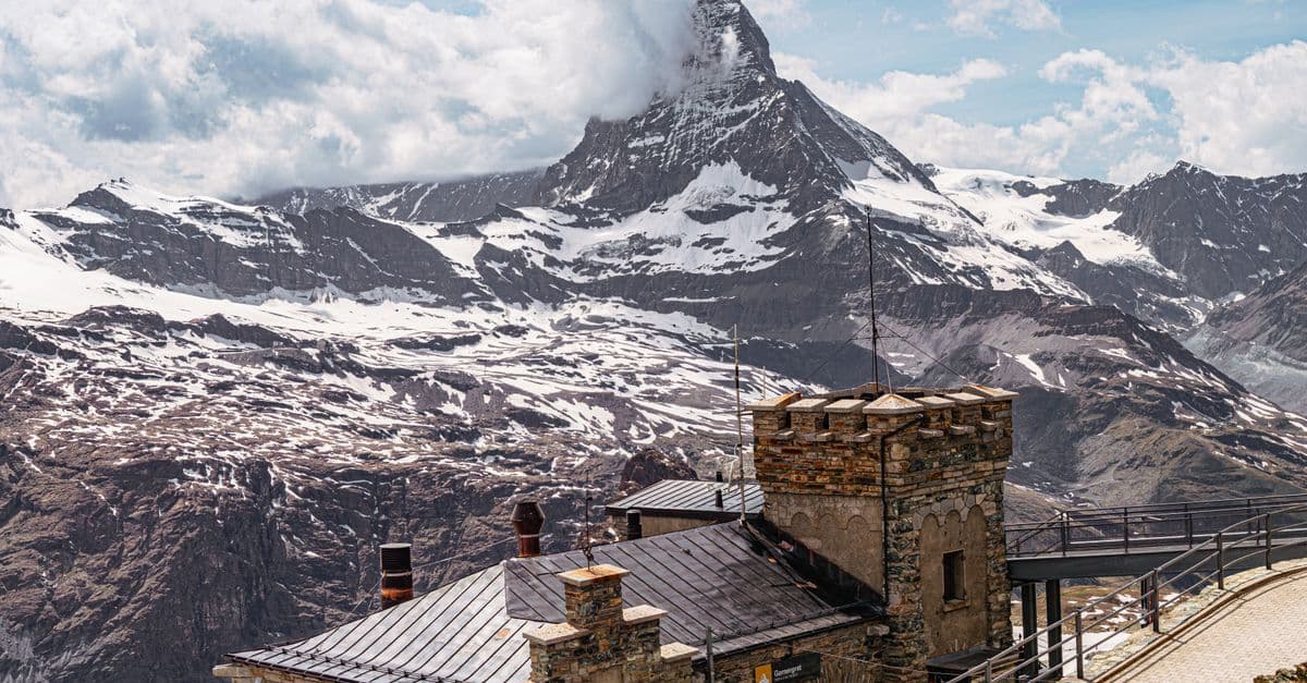 Imposante Aussicht auf das Matterhorn in Zermatt mit einem historischen Berggebäude im Vordergrund.