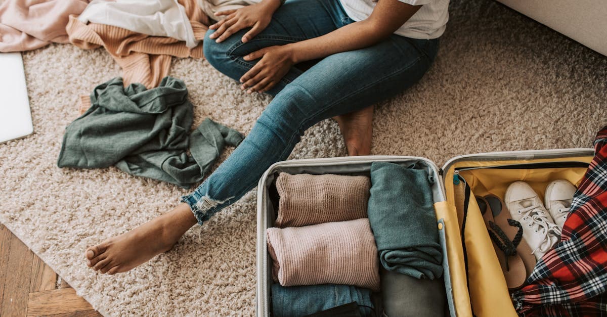 Woman organizing clothing and essentials on the floor while preparing her Ireland packing list