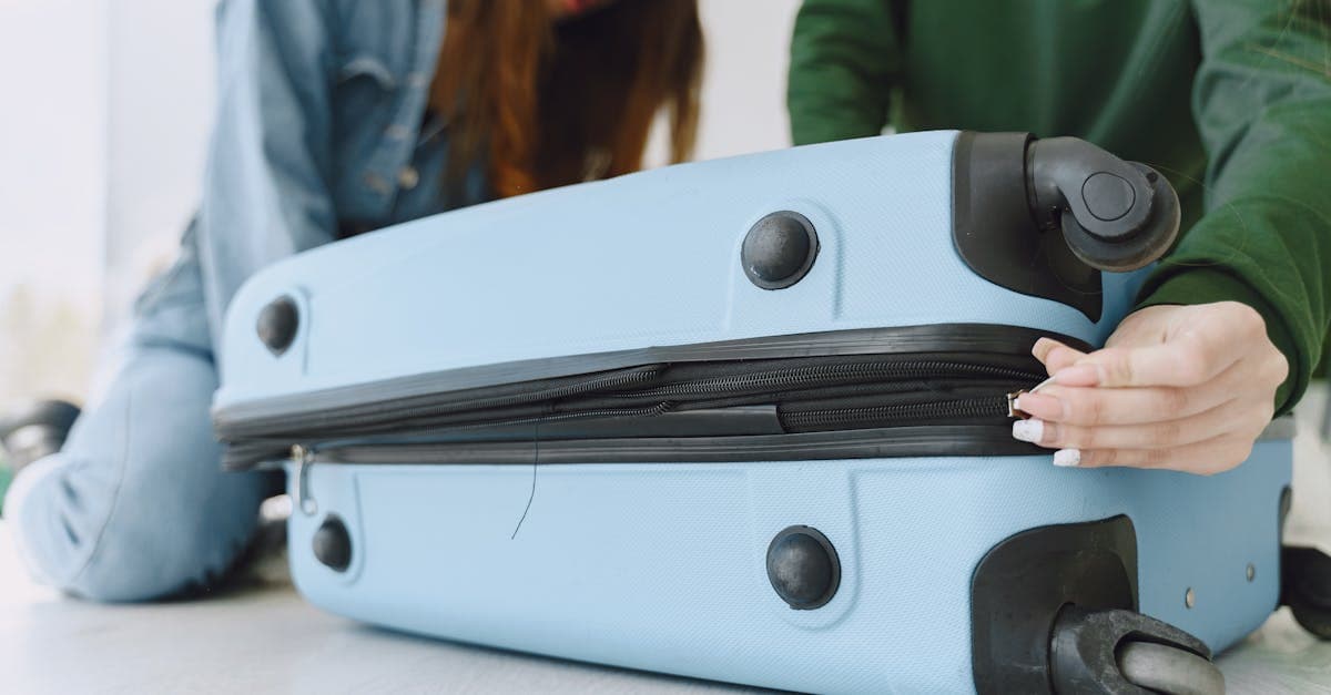 Deux femmes préparant et remplissant une valise bleue avant un voyage