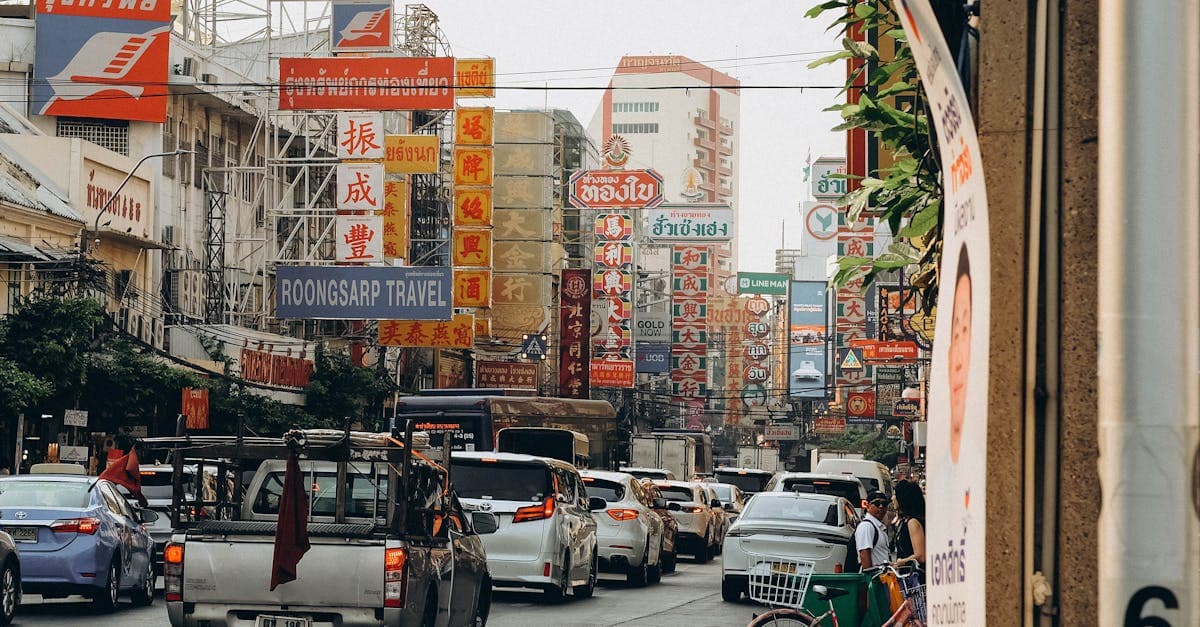Livfull gatuvy i Bangkoks Chinatown med lysande skyltar och tät trafik.