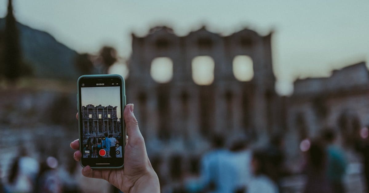 Gün batımında antik kalıntıları telefonla fotoğraflayan turistler; roaming ne demek Türkçe karşılığını merak ediyor