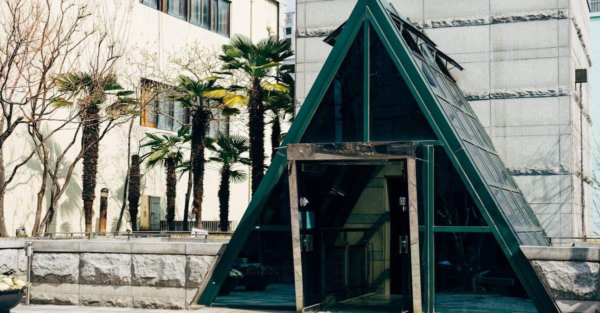 부산의 야자수로 둘러싸인 현대적인 유리 건물 입구, 한국 디지털 노마드 비자 신청 절차를 준비하는 공간