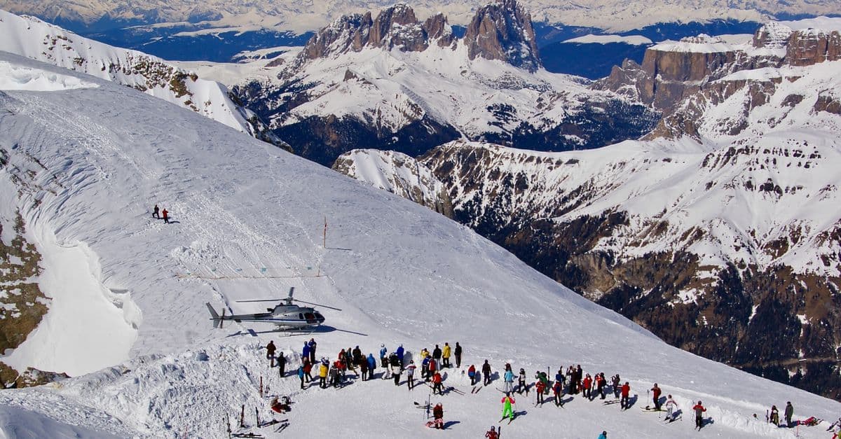 Sciatori sulle piste delle Dolomiti in Val di Fassa, perfetta per vacanze invernali in family hotel trentino.