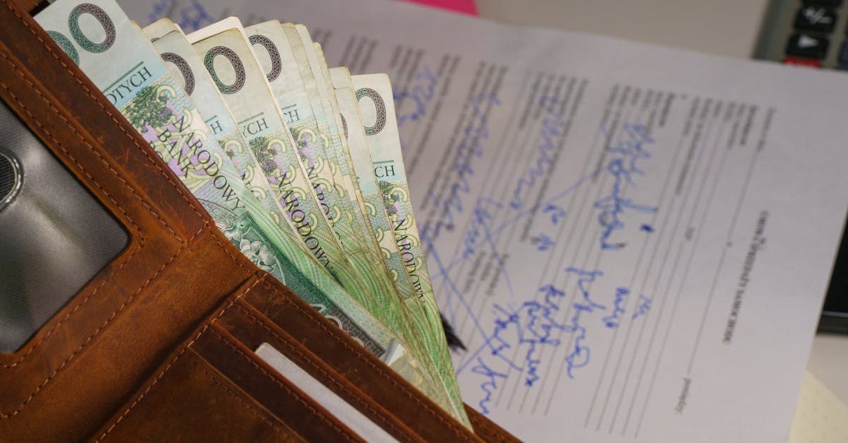 Portfel z polskimi złotymi i podpisany dokument: rozliczenie podatku przy pracy za granicą.