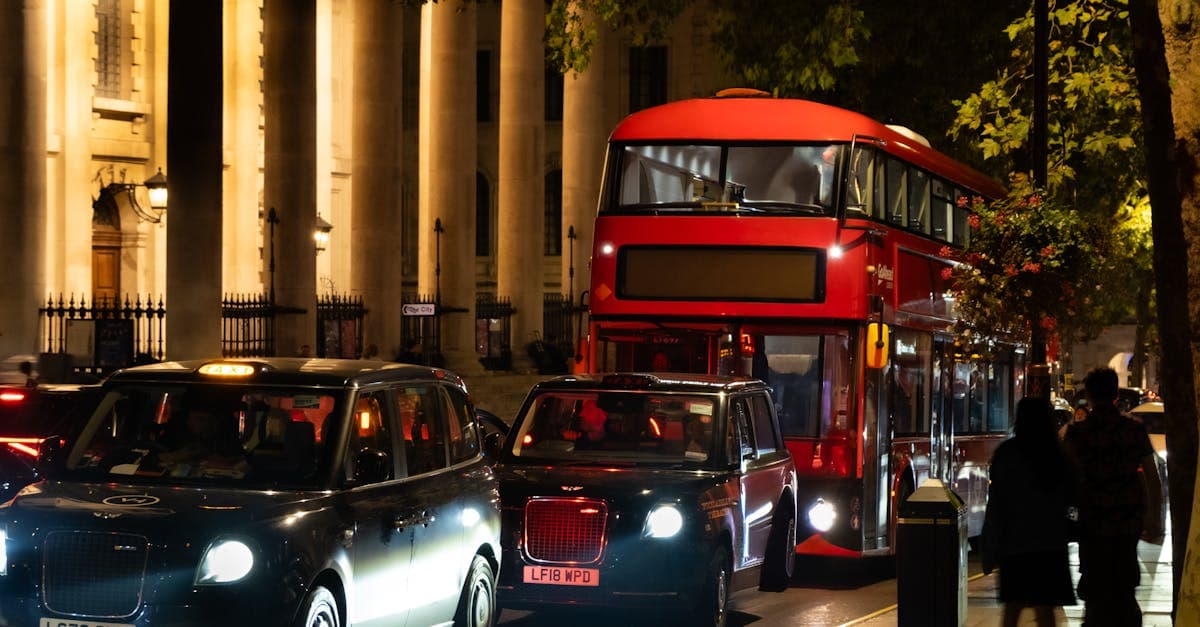 Autobus rosso a due piani e taxi neri londinesi di notte, iconici mezzi di trasporto per visitare la città