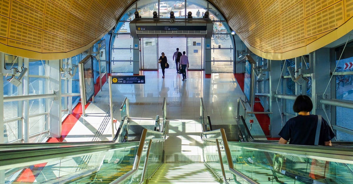 Sonnendurchflutete Metro-Station am Flughafen Dubai mit Rolltreppen und reisenden Passagieren