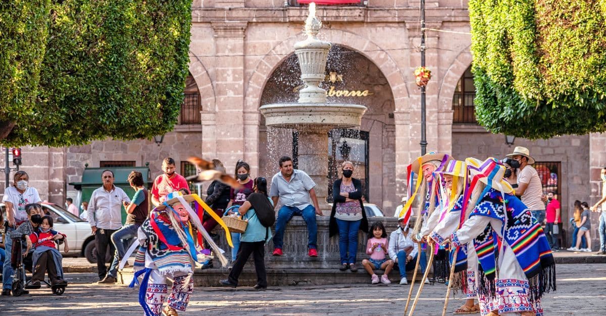 Danza tradicional regional en la plaza principal de Morelia, México, con trajes coloridos y ambiente festivo.