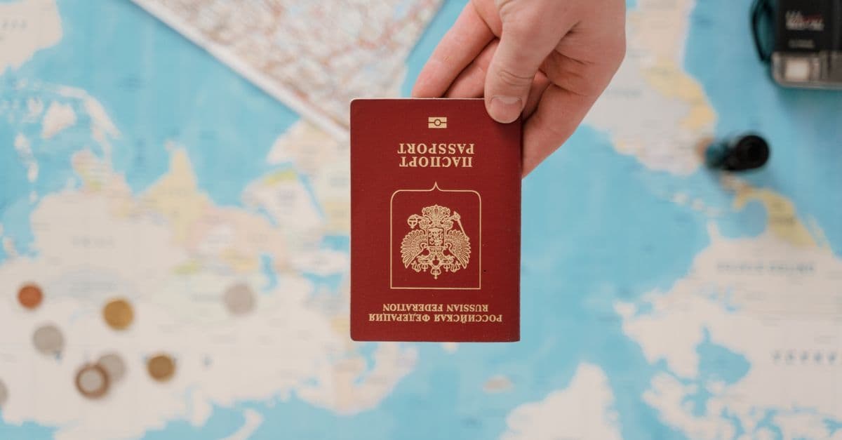 Main tenant un passeport au-dessus d'une carte, symbole des documents requis pour obtenir un visa Thaïlande