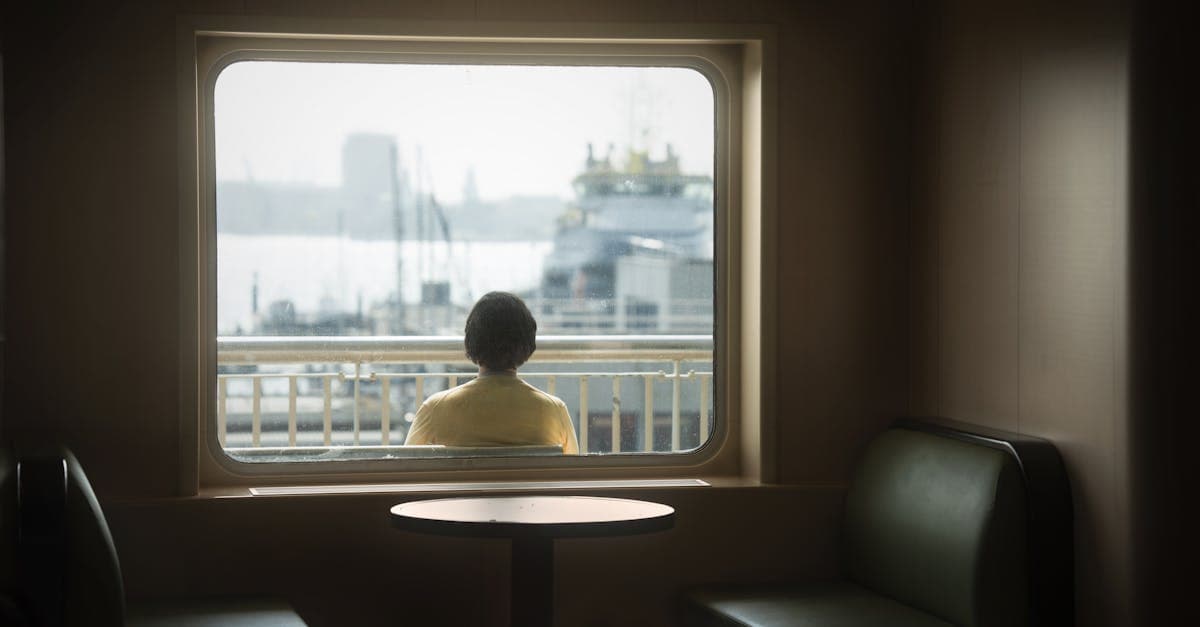 Femme contemplant le paysage marin depuis un ferry, choisissant sa prochaine destination pour voyager seul