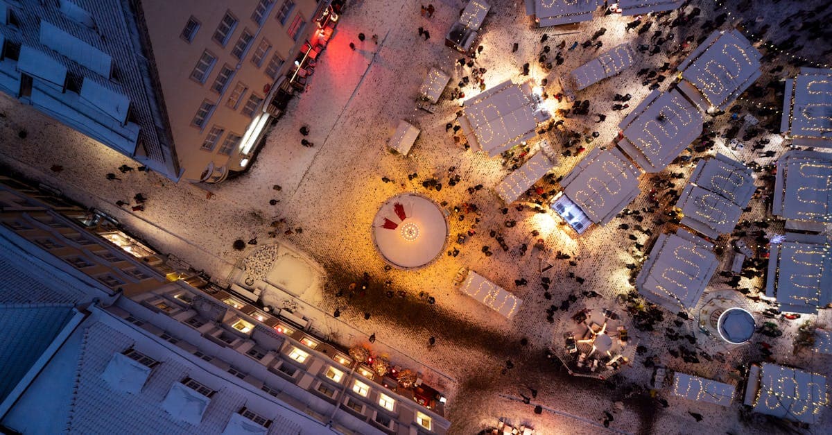 Aerial view of Tallinn's illuminated Christmas market at night with snow, among the best Europe cities to visit in December