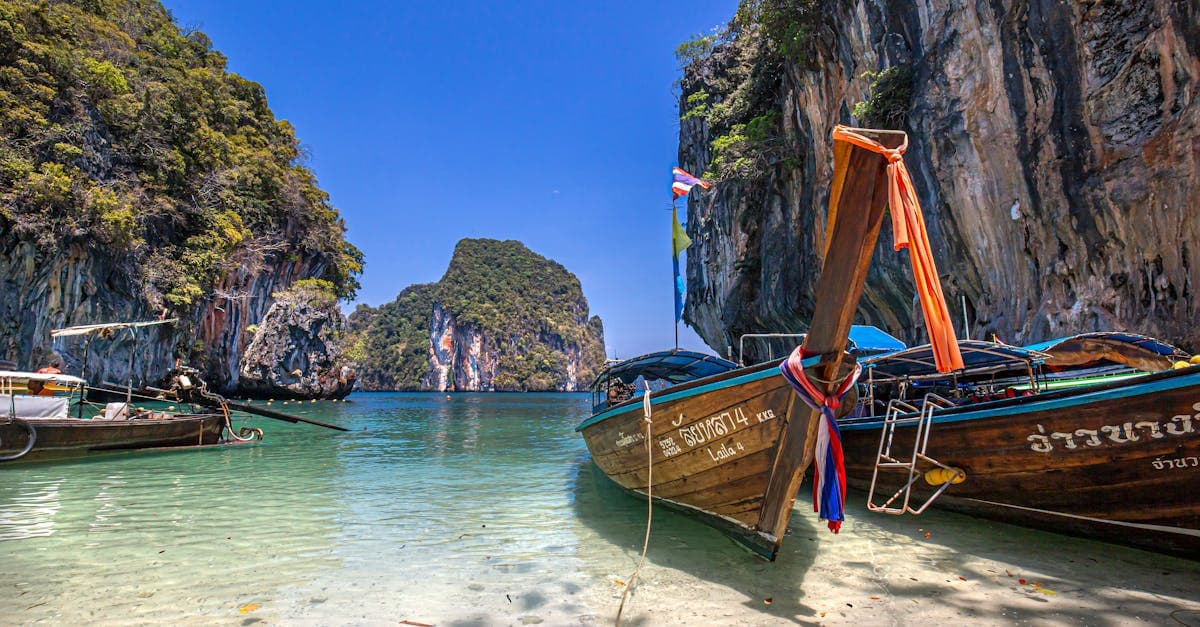Longtail-Boote ankern im klaren Wasser von Ao Nang vor Kalksteinfelsen, ideales Motiv für den Thailand Urlaub