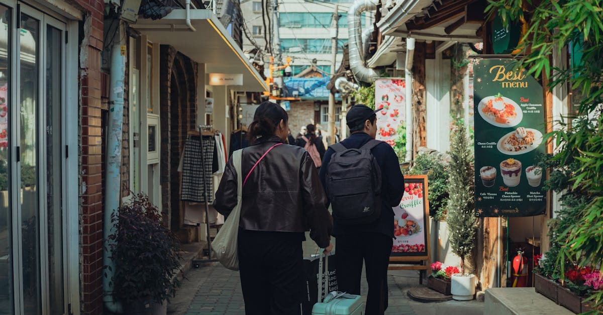 食べ物や地元の店が並ぶソウルの活気ある路地を歩く二人、韓国旅行に持って行くべき持ち物の参考