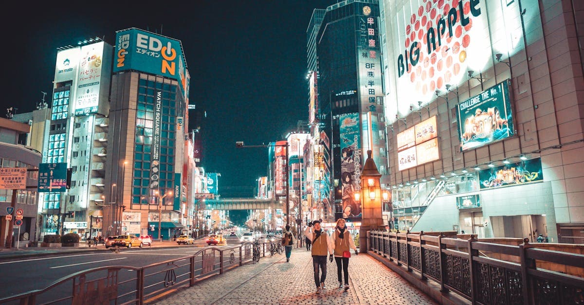 Japonya'da gece parlayan binalar ve caddelerde yürüyen insanlarla modern şehir manzarası