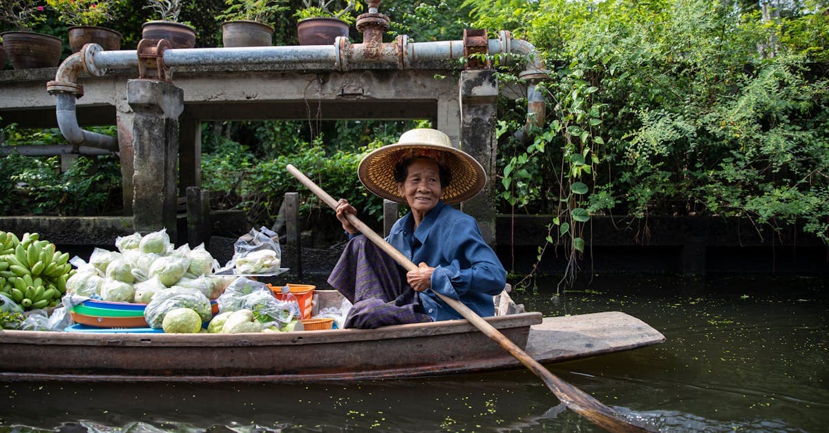 Local woman selling fresh produce from a boat on a scenic Southeast Asian floating river market