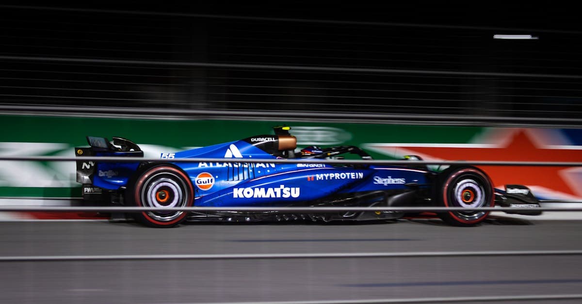 Niebieski bolid F1 rozpędzony na torze podczas nocnego wyścigu sezonu f1 2026.