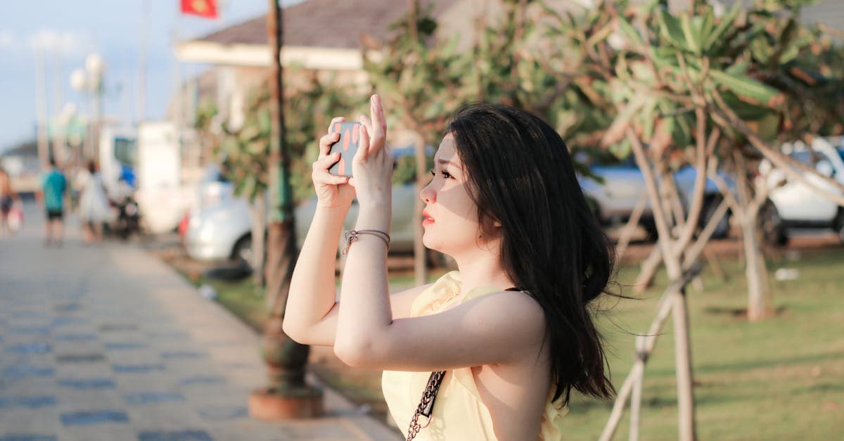 Cô gái trẻ mặc váy vàng chụp ảnh ngoài trời, minh họa cách sử dụng roaming Vinaphone khi du lịch.