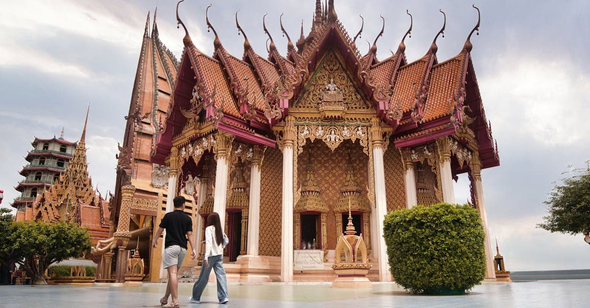 Couple exploring a traditional Thai temple with intricate architecture, representing stunning places to visit in Thailand