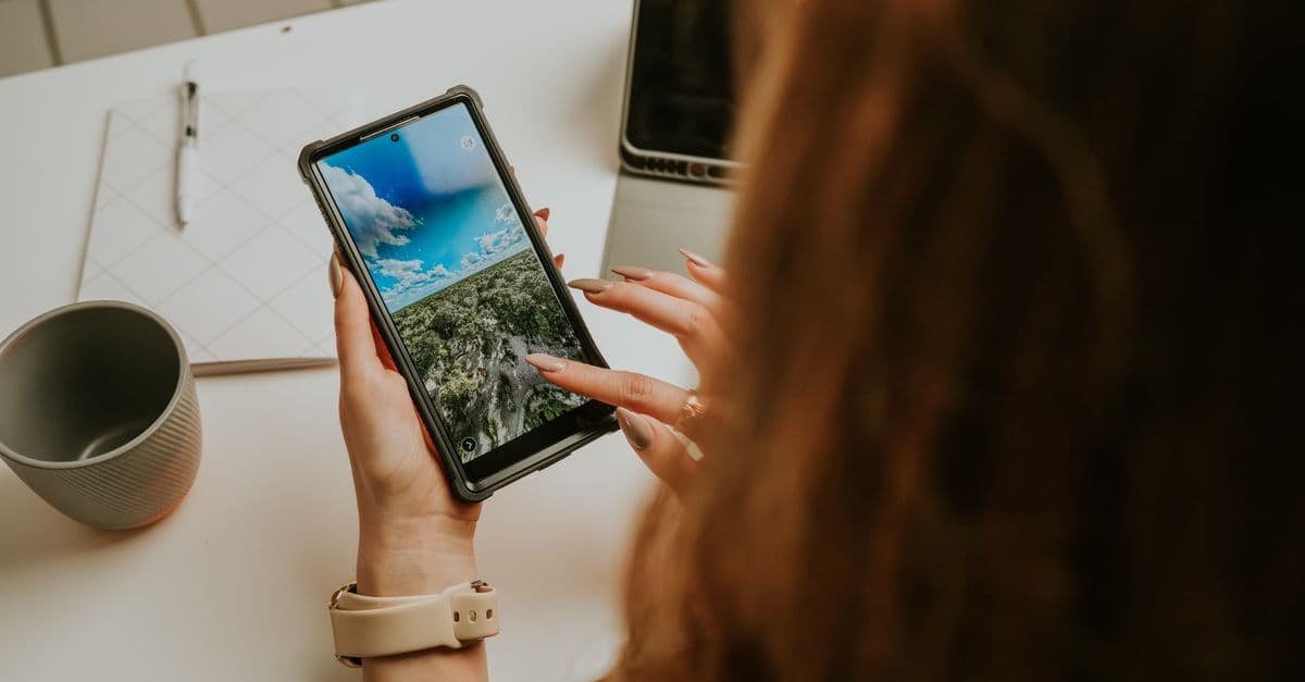 Mulher utilizando smartphone moderno na mesa do escritório para entender como o eSIM funciona