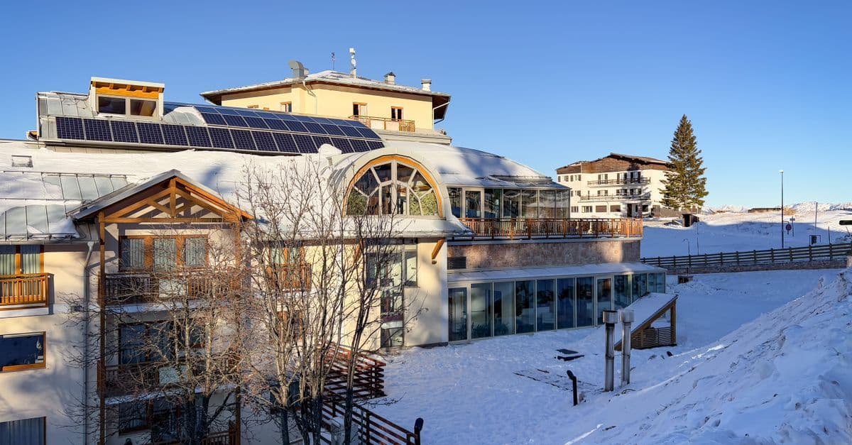 Borgo alpino innevato nelle Dolomiti trentine, meta ideale per famiglie con bambini.