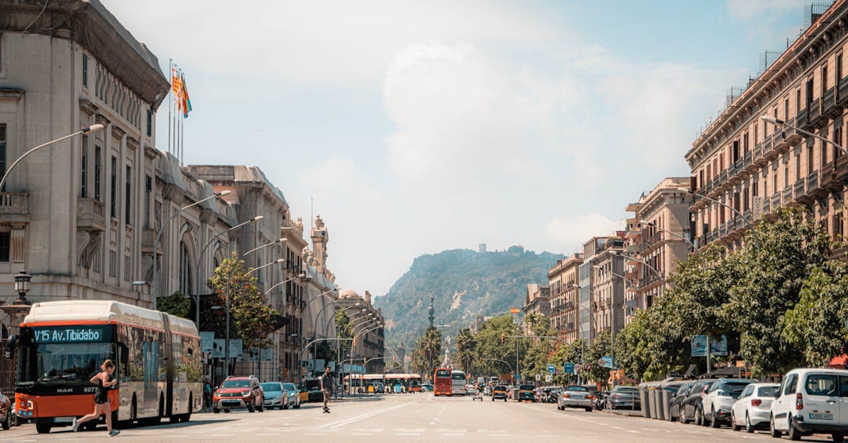 Lively Barcelona street scene with classic architecture and Montjuïc mountain visible in the background