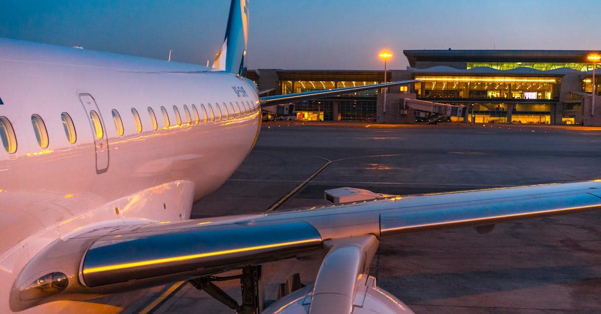 Passagierflugzeug parkt bei Abenddämmerung am beleuchteten Terminal des Rhodos Flughafens.