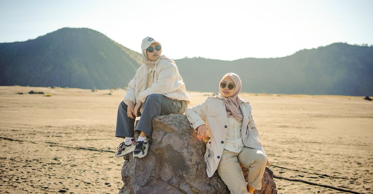 Dua wisatawan berbusana sederhana menjelajahi lanskap Gunung Bromo, cocok untuk perjalanan domestik maupun internasional.