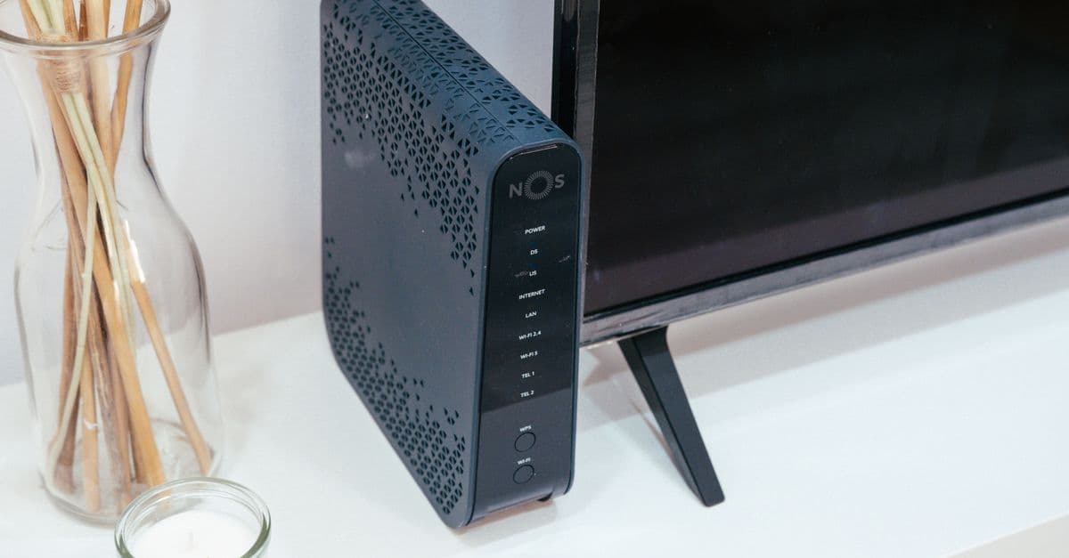 Thuisopstelling met router, glazen decoratie en televisie voor optimale wifi-dekking.