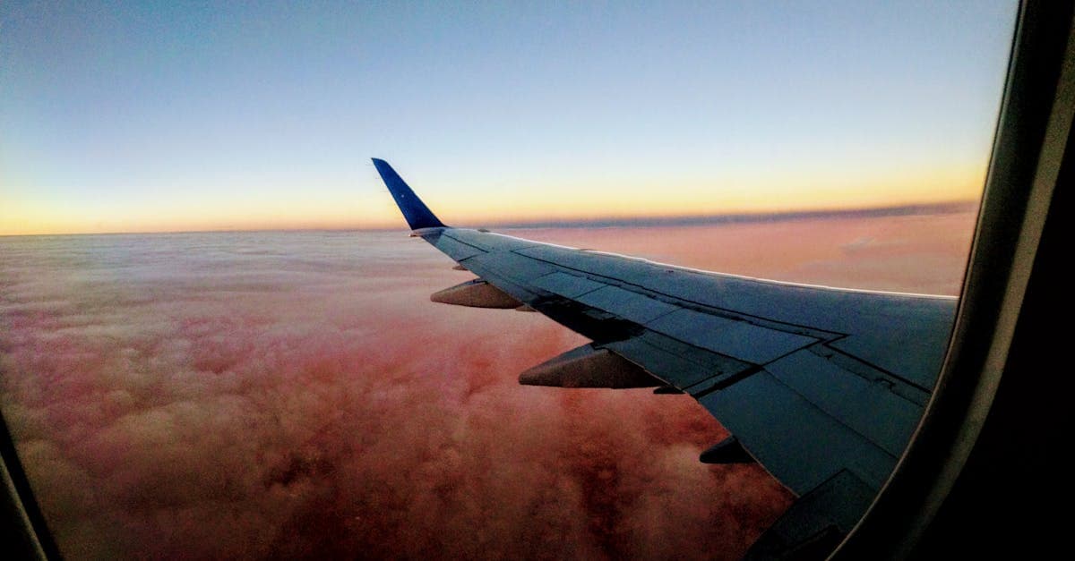 Airplane wing silhouetted against a vivid sunset sky, capturing the spirit of international roaming from Australia