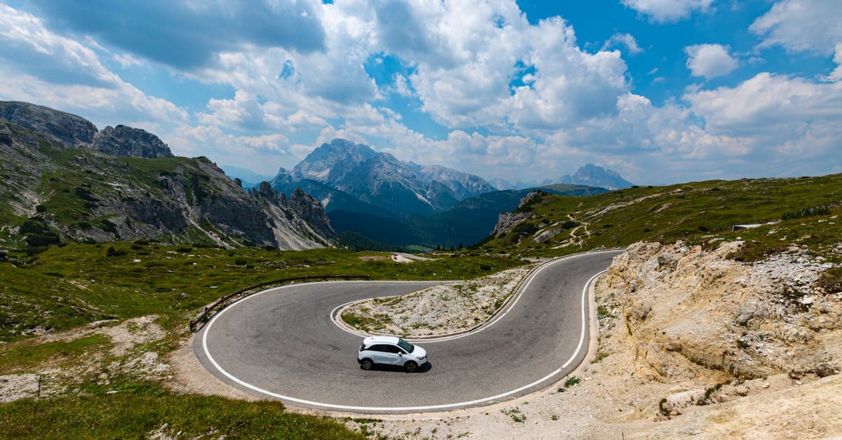 Auto su una strada di montagna tortuosa in Veneto, utile per stimare i costi di pedaggi e carburante