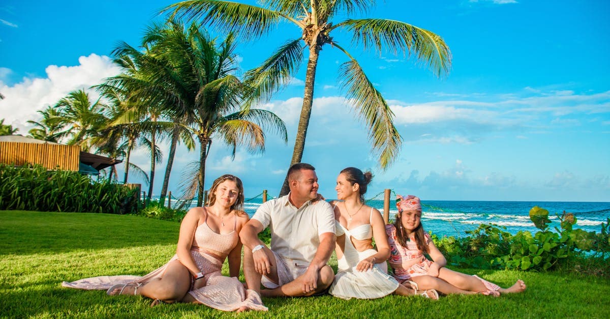 Family relaxing on a tropical oceanside lawn in Cancun with palm trees on a sunny day