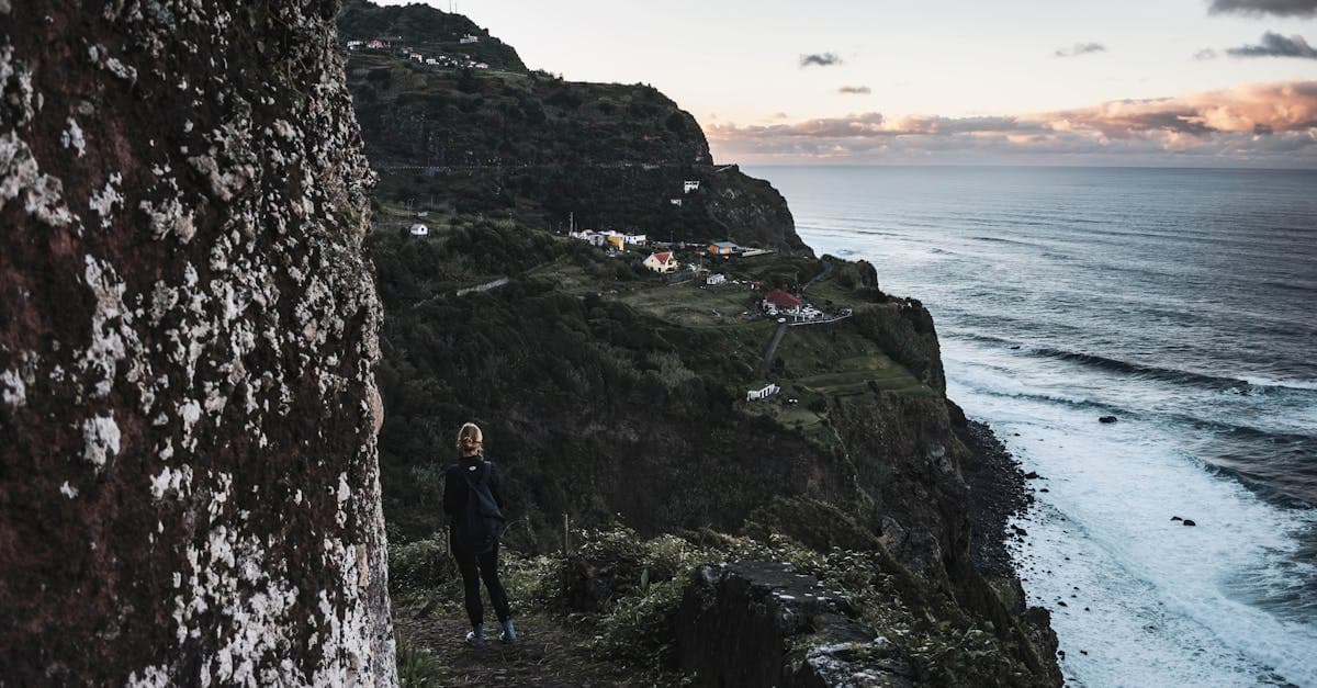 Wanderer auf dem Klippenweg in Madeira bei Abendlicht genießt den Blick auf den Atlantik
