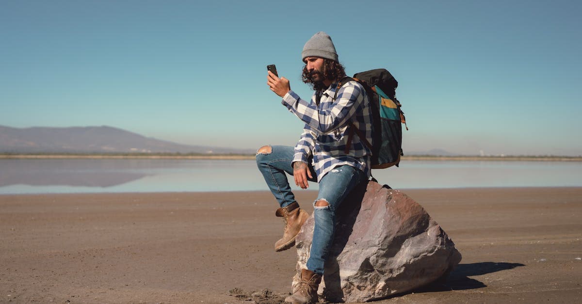 مسافر يتصفح هاتفه الذكي في الطبيعة مستخدماً شريحة eSIM للسفر للبقاء متصلاً بالإنترنت في سيشيل