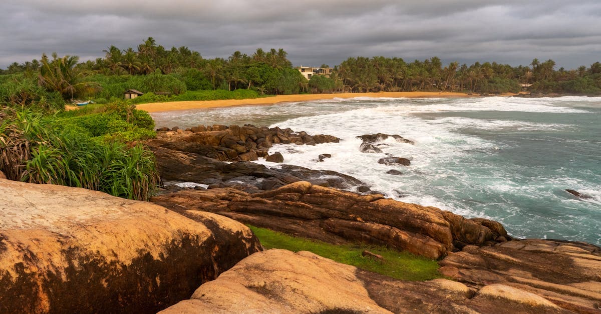 Rocky Sri Lanka shoreline at sunset, illustrating the contrast between wet and dry monsoon seasons