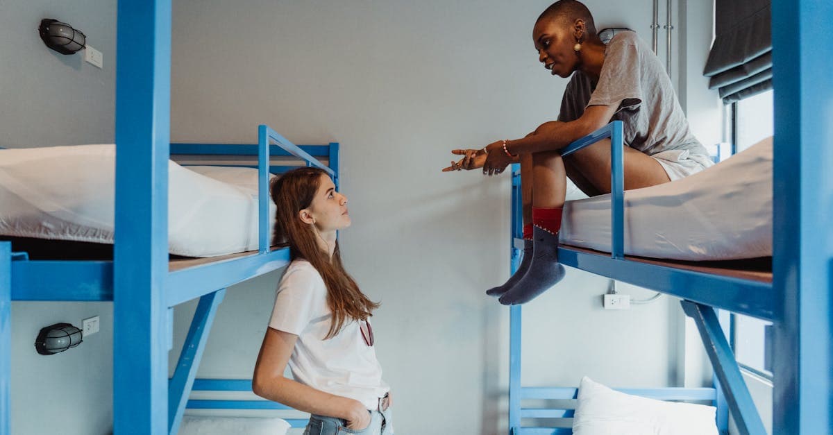 สองผู้หญิงคุยกันบนเตียงสองชั้นในโฮสเทล ทางเลือกราคาประหยัดแทนโรงแรมราคาถูกในไทย