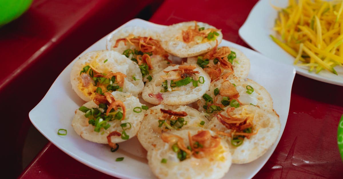 Bánh Căn rice pancakes topped with scallions and crispy shallots, a regional vietnamese street food