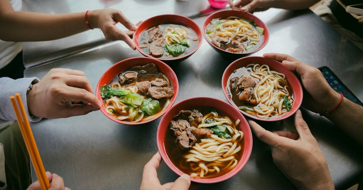 台湾で最も有名な食べ物・牛肉麺を箸で味わう、仲間と囲む食卓の俯瞰シーン