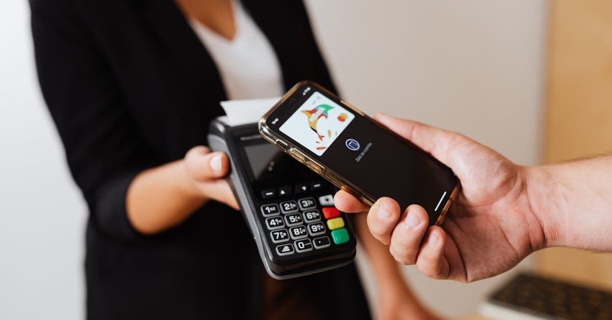 Customer at a shop counter topping up a Tesco pay as you go SIM using a smartphone.