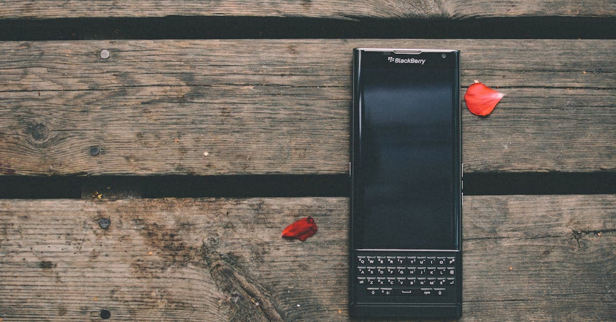 Discarded blackberry phone on a rustic wooden table with red flower petals, symbolizing the brand's decline.