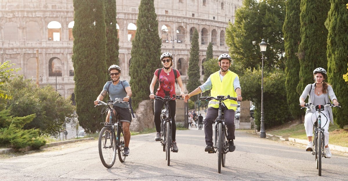 Cyclists on a group food tour rome pedaling past the Colosseum on a bright summer day