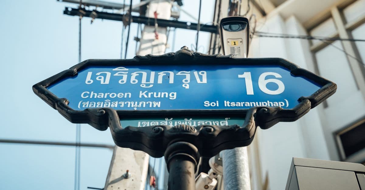 Classic Bangkok street sign on Charoen Krung Road helping travelers understand time in thai language