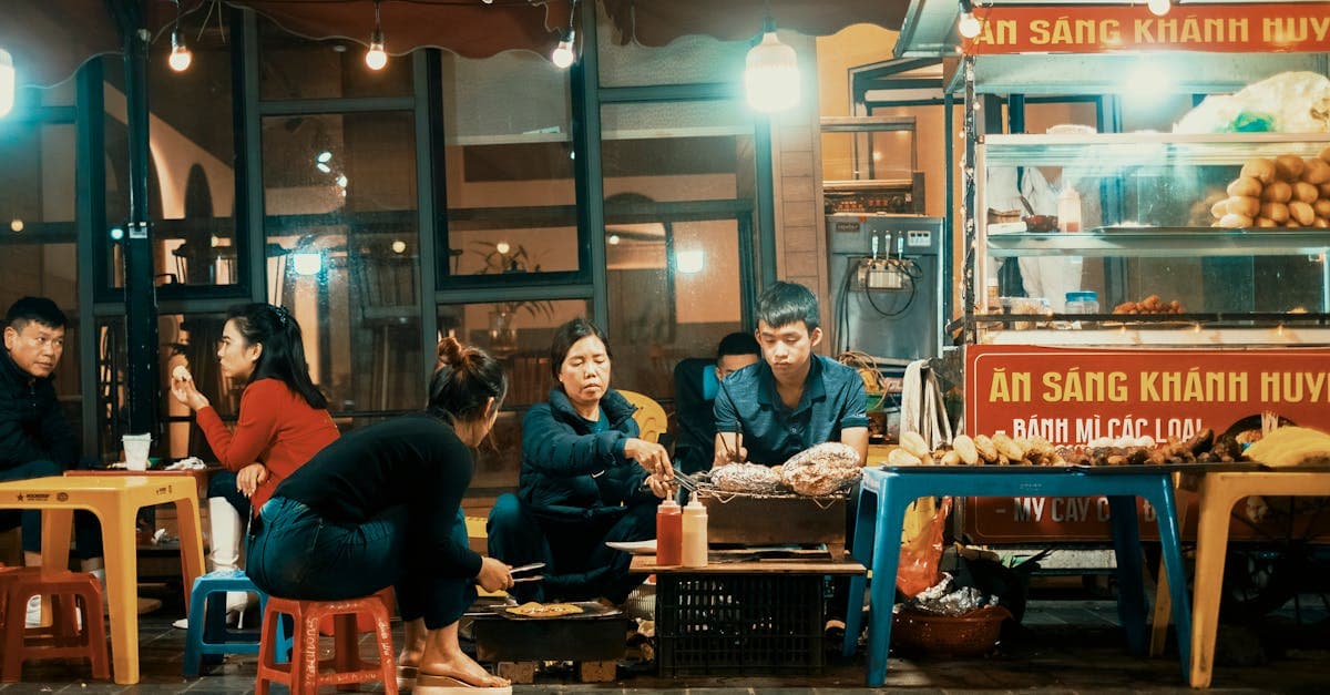 Group of travellers enjoying vietnamese street foods together at a lively night market