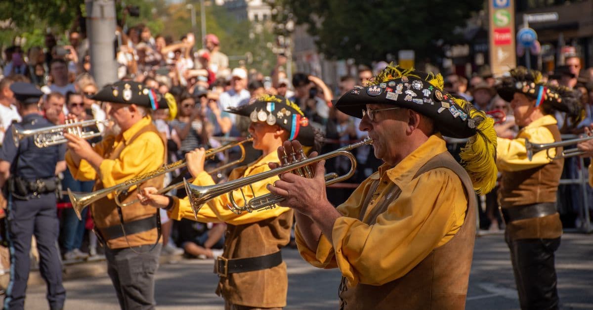 Trachtenkapelle spielt zum offiziellen Festbeginn des Gauderfests vor jubelnden Zuschauern in festlicher Stadtkulisse.