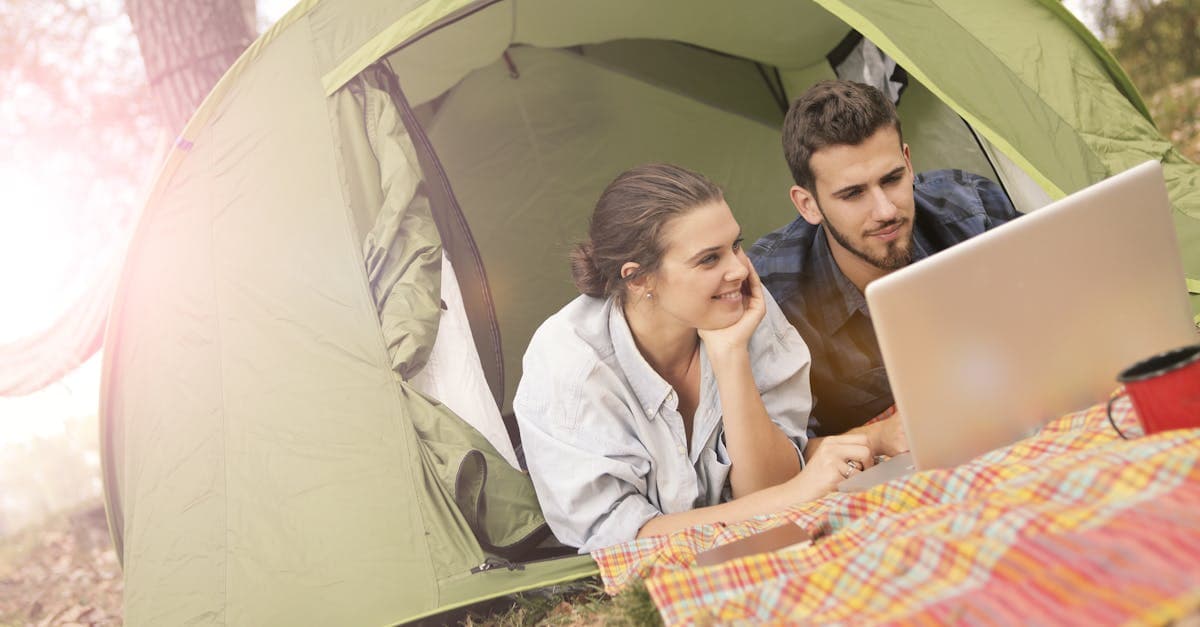 Stel in tent met laptop regelt wifi en mobiele data voor hun camping Zuid-Frankrijk avontuur