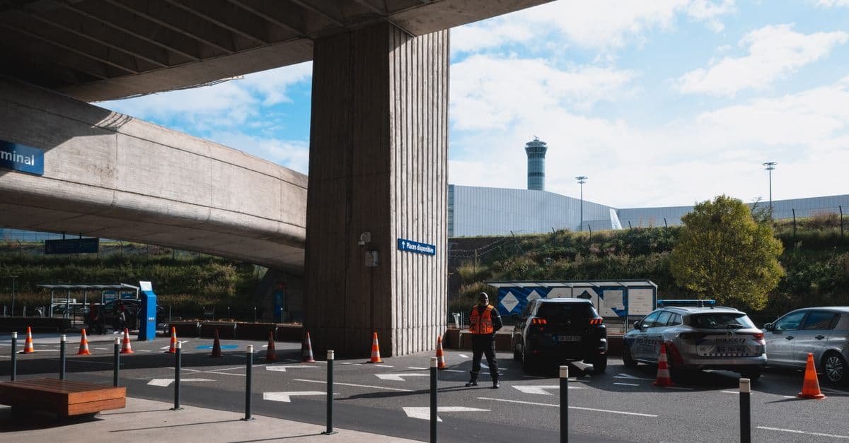 Reizigers en voertuigen bij de ingang van Düsseldorf Airport, klaar voor vertrek of aankomst.